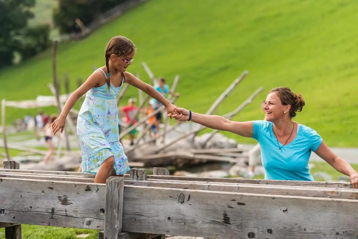 Familie balanciert über den Wasserlauf